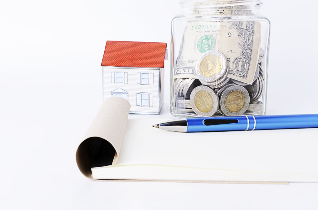 Деньги на фоне жилого дома — расчет необходимого дохода для ипотеки