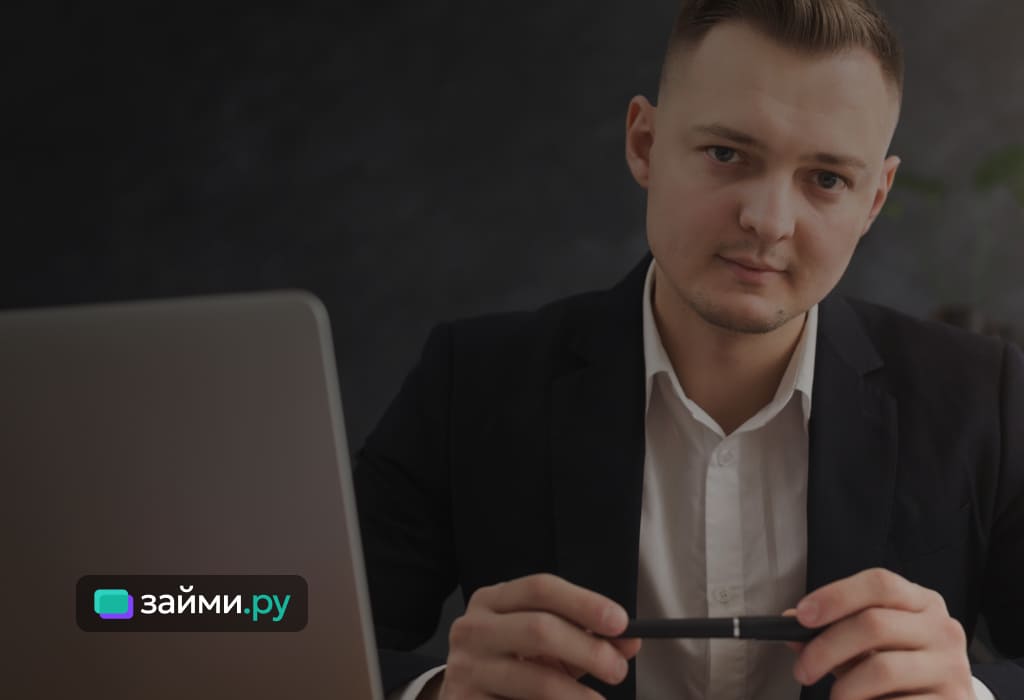 представитель Альфа-Банка - мужчина читает отчет, сидя за столом, крупным планом