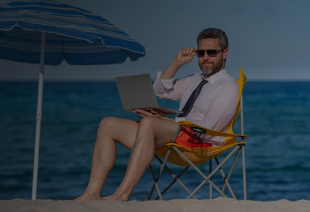 Мужчина с ноутбуком на пляже – образ жизни на пассивный доход от вложений