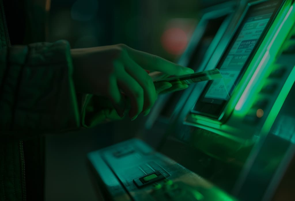 Банкомат на зеленом фоне, символизирующий снятие наличных без комиссии по карте Ак Барс