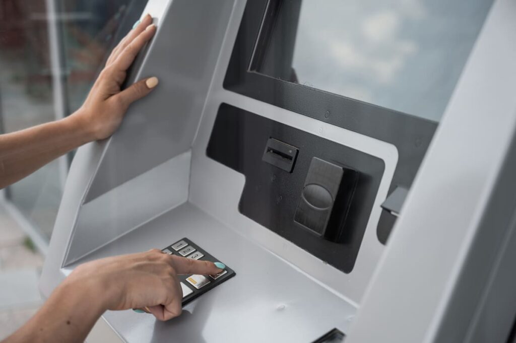 человек набирает пин на банкомате