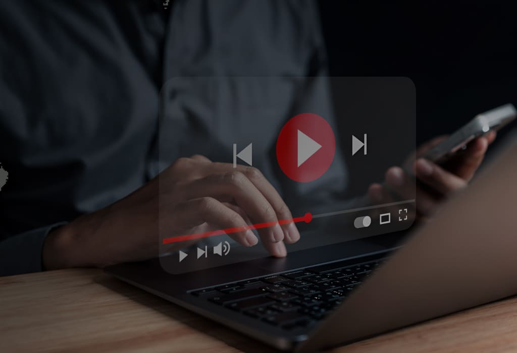 человек работает за ноутбуком с интерфейсом плеера