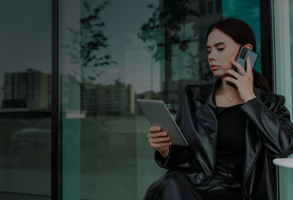 девушка говорит по телефону держа планшет