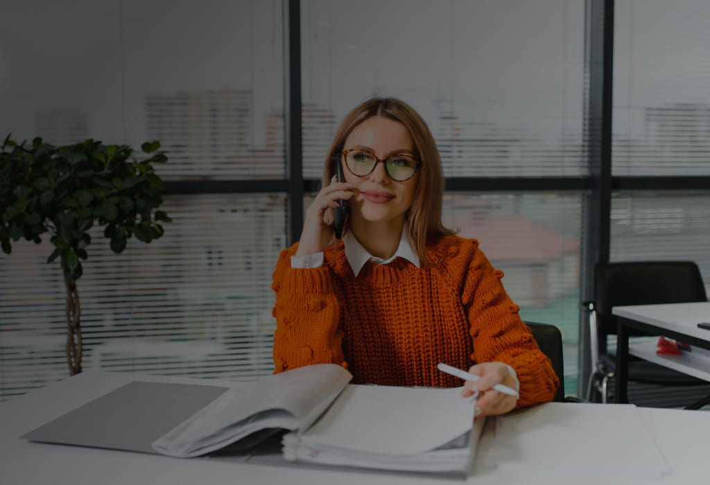 женщина получает консультацию по телефону от банка Уралсиб